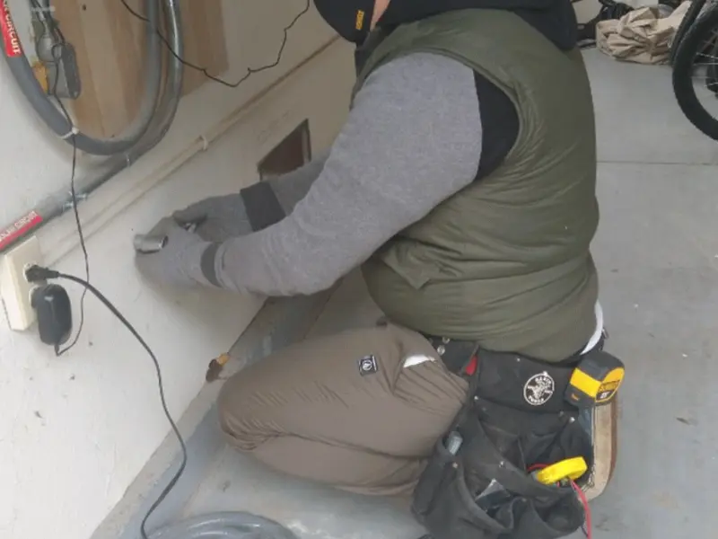Electrician performing outlet wiring in a Conyers garage